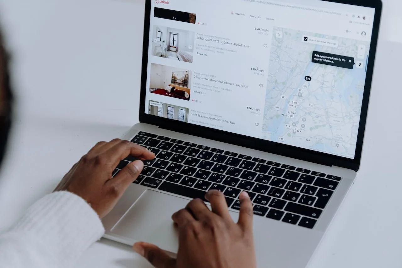 Ragazza property manager che controlla al telefono prenotazioni su Airbnb